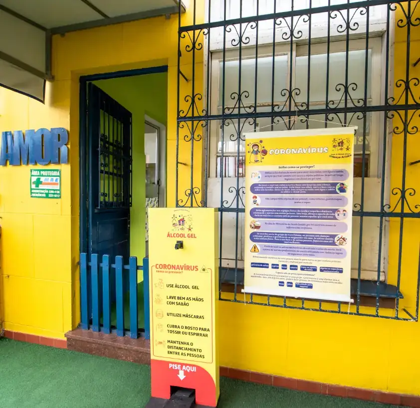 Crianças sentadas à mesa fazendo o lanche no refeitório da escola