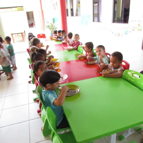 Refeição em grupo servida na mesa do refeitório infantil